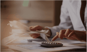 business professional holding receipts while using calculator