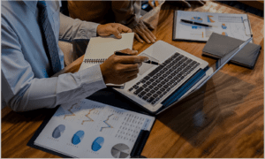 Business professional dressed up pointing to computer screen with pin