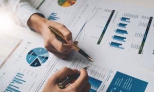 business meeting with people pointing to graphs and charts