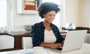 Women working at home on computer in kitchen