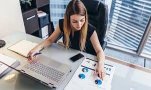 Professional business women working with computer and papers at desk