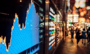 stock market graph being displayed in busy street