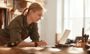 Woman leaning on table working on computer