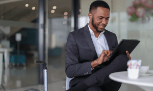 Business man in suit working on tablet while at a table