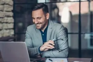 Business man smiling and looking at computer