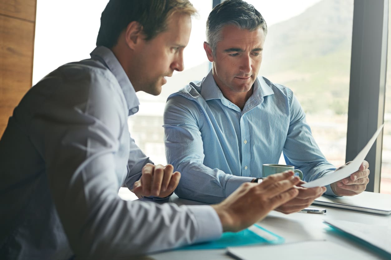 Shot of two men discussing financial growth strategies for a business.